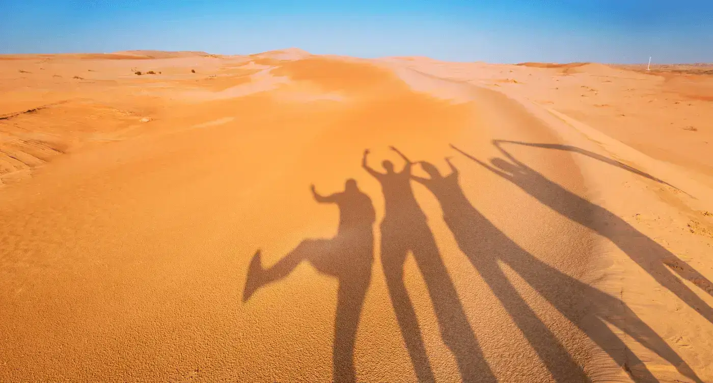 A group of friends' shadows on sand