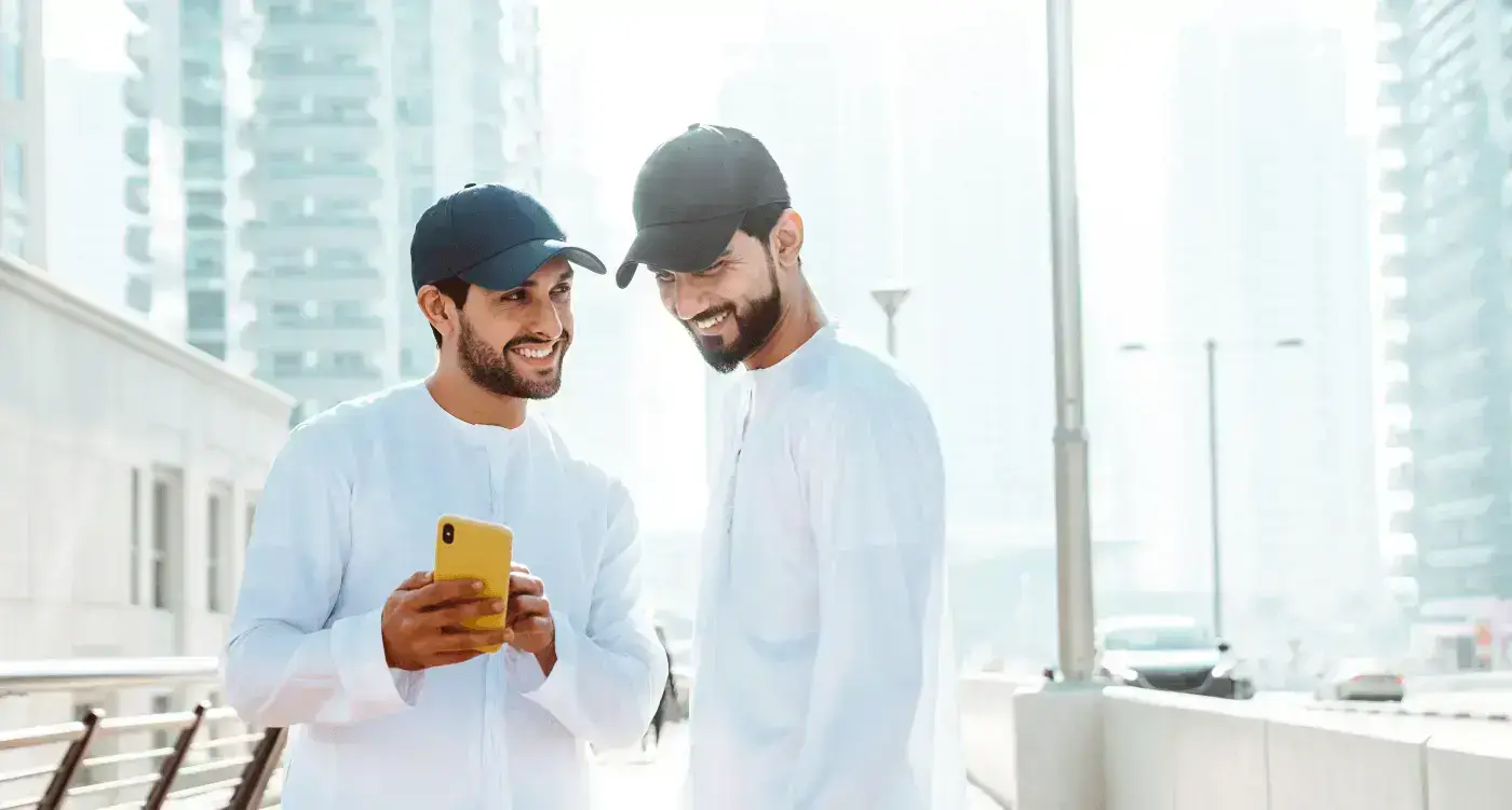 A guy showing his friend something on his mobile